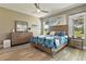 Main bedroom with wood-look floors, a ceiling fan, and windows looking out to the yard at 1951 San Silvestro Dr, Venice, FL 34285