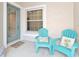 Charming patio featuring colorful Adirondack chairs and a welcoming beach-themed doormat at 1951 San Silvestro Dr, Venice, FL 34285