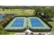 A pristine tennis court area for recreational activities featuring manicured greenery and access to nearby parking at 1951 San Silvestro Dr, Venice, FL 34285