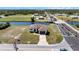 Waterfront property featuring a modern home, a brown roof, and paved driveway near intersecting roads at 197 Rotonda Cir, Rotonda West, FL 33947