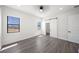 Sunlit bedroom with wood floors, two windows, modern ceiling fan and convenient access to the ensuite bathroom at 197 Rotonda Cir, Rotonda West, FL 33947