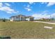Modern, light gray home with a brown roof and a beautifully paved driveway and front lawn at 197 Rotonda Cir, Rotonda West, FL 33947