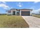 Modern, light gray home with a brown roof, matching brown garage door and a beautifully paved driveway at 197 Rotonda Cir, Rotonda West, FL 33947