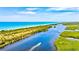 Beautiful aerial view of a beach with boat navigating through mangrove-lined waters under a clear blue sky at 22324 Wexford Blvd, Venice, FL 34293