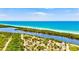 Scenic aerial image capturing a tranquil waterway flowing into a beach, surrounded by dense, green foliage at 22324 Wexford Blvd, Venice, FL 34293