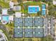 Aerial view of a community showcasing pools, pickleball and tennis courts, and well-maintained grounds at 22324 Wexford Blvd, Venice, FL 34293