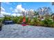 Outdoor patio featuring a red fire-pit, lush green landscaping and a tiled patio area perfect for relaxing outdoors at 22324 Wexford Blvd, Venice, FL 34293