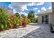 Landscaped backyard featuring a stone patio, a fire pit, and lush greenery at 22324 Wexford Blvd, Venice, FL 34293