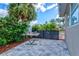Outdoor backyard featuring a hammock, lush green landscaping, and a tiled patio area perfect for relaxation at 22324 Wexford Blvd, Venice, FL 34293