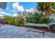 Backyard with a hammock, lush green landscaping, and a brick paved patio area perfect for outdoor relaxation at 22324 Wexford Blvd, Venice, FL 34293