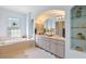 Elegant bathroom featuring a soaking tub, glass shelving, and a double sink vanity at 22324 Wexford Blvd, Venice, FL 34293