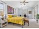 Bedroom with a tray ceiling, neutral carpet, desk, and a bed with a yellow quilt at 22324 Wexford Blvd, Venice, FL 34293