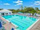 Beautiful community pool with lounge chairs and tables with umbrellas creating a relaxing and inviting atmosphere at 22324 Wexford Blvd, Venice, FL 34293