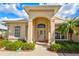 Elegant home entrance with decorative door, manicured bushes, and warm lighting to welcome visitors at 22324 Wexford Blvd, Venice, FL 34293