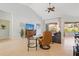 Cozy living area with comfortable furnishings, tile flooring, a ceiling fan, and outdoor views at 22324 Wexford Blvd, Venice, FL 34293