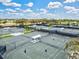 Multiple tennis courts with players engaged in a match, surrounded by lush landscaping and open skies at 22324 Wexford Blvd, Venice, FL 34293