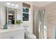 Neutral bathroom featuring a white vanity, a large mirror and shower with a striped curtain at 2309 Chardonnay Ter, Parrish, FL 34219