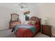 Cozy bedroom featuring a queen bed, a ceiling fan and stylish matching wood furniture at 2309 Chardonnay Ter, Parrish, FL 34219