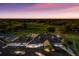 Community clubhouse with beautiful landscaping and golf course, illuminated by the light of the setting sun at 2309 Chardonnay Ter, Parrish, FL 34219