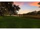 Beautiful lake view showing trees and sunset and a grassy hill in the foreground at 2309 Chardonnay Ter, Parrish, FL 34219