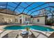 Beautiful pool area with lounge chairs in screened in lanai and manicured landscaping at 2309 Chardonnay Ter, Parrish, FL 34219