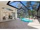 Screened-in pool area with brick patio and a view of lush greenery at 2309 Chardonnay Ter, Parrish, FL 34219