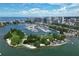 Scenic aerial view of a marina on the coast, surrounded by lush greenery, buildings, and sparkling blue water at 2350 Novus St, Sarasota, FL 34237