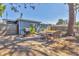 Backyard patio featuring a grill, outdoor seating, luscious green plants, a shed, and fencing at 2350 Novus St, Sarasota, FL 34237