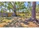 Backyard with seating under a large tree, with a stepping stone path, grass, and fencing at 2350 Novus St, Sarasota, FL 34237