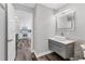 Bathroom featuring a modern sink with grey drawers and light-up mirror with kitchen in background at 2350 Novus St, Sarasota, FL 34237