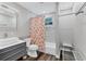 Bathroom featuring a shower with orange floral curtain and modern sink with grey drawers at 2350 Novus St, Sarasota, FL 34237