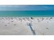 Aerial shot of a white sandy beach with clear blue ocean, many people, and boardwalk access at 2350 Novus St, Sarasota, FL 34237