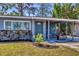 Inviting covered porch with seating area and garden art adds curb appeal to this cozy home at 2350 Novus St, Sarasota, FL 34237