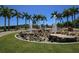 Water feature in Payne Park, with many Palm trees, rocks, and green grass at 2350 Novus St, Sarasota, FL 34237