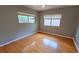 Bright bedroom with hardwood floors, neutral paint, ceiling fan, and two large windows at 3004 Bay Shore Cir, Sarasota, FL 34234