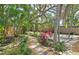 Stone pathway leading to backyard bocce ball court with mature trees and landscaping at 3004 Bay Shore Cir, Sarasota, FL 34234