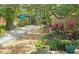 Backyard bocce ball court with lush landscaping and an outdoor seating area at 3004 Bay Shore Cir, Sarasota, FL 34234