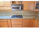 Kitchen featuring wood cabinets, granite countertops, stainless steel microwave and gas range at 3004 Bay Shore Cir, Sarasota, FL 34234