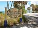Sign for Indian Beach Sapphire Shores neighborhood near palm trees and Tampa Bay at 3004 Bay Shore Cir, Sarasota, FL 34234