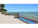 Scenic waterfront view of Tampa Bay from a wooden deck with benches and palm trees at 3004 Bay Shore Cir, Sarasota, FL 34234