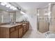 Elegant bathroom featuring double sinks, granite countertops, a glass-enclosed shower and large mirrors at 316 64Th St, Holmes Beach, FL 34217