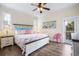 Bright bedroom featuring a king-size bed, ceiling fan, and access to a private balcony at 316 64Th St, Holmes Beach, FL 34217