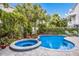 Sparkling pool and spa surrounded by lush, tropical landscaping with brick pavers at 316 64Th St, Holmes Beach, FL 34217