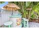 Outdoor tiki bar with barstools, signage, and tropical landscaping for entertaining at 316 64Th St, Holmes Beach, FL 34217