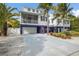 Charming two-story stilt home featuring a two-car garage and a welcoming screened porch at 316 64Th St, Holmes Beach, FL 34217