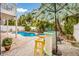 Inviting backyard featuring a private pool, tiki bar, lush landscaping, and lounge chairs at 318 64Th St, Holmes Beach, FL 34217