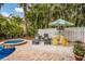 Backyard with a pool, spa, lush greenery, tiki bar and lounge chairs for relaxing outdoors at 318 64Th St, Holmes Beach, FL 34217