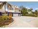 Charming stilted home featuring blue accents, a metal roof, a well-manicured lawn, and a spacious driveway at 318 64Th St, Holmes Beach, FL 34217