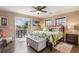 Bright main bedroom with a ceiling fan, balcony access, and coordinated decor at 318 64Th St, Holmes Beach, FL 34217