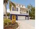 Two-story coastal home featuring a yellow entry door, upper balcony and a convenient ground-level garage at 318 64Th St, Holmes Beach, FL 34217